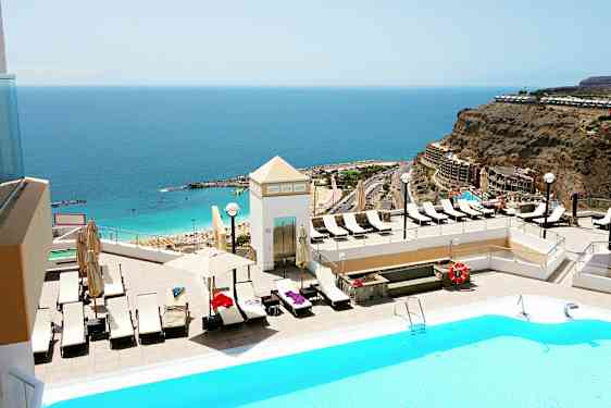 Poolområde med udsigt over havet og en strand. (AI-genereret tekst)