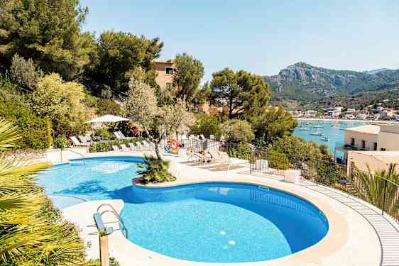 Udendørs swimmingpool med udsigt over en havbugt og bjerge i baggrunden. (AI-genereret tekst)