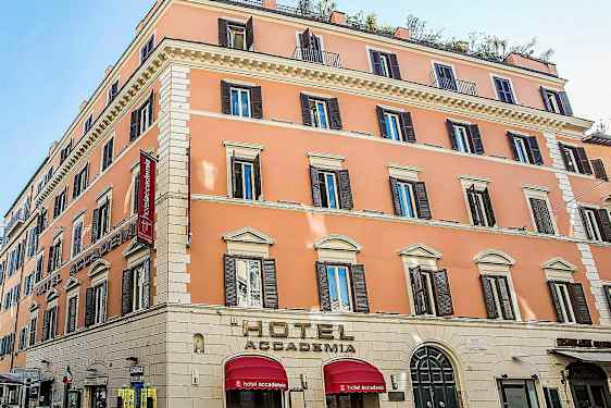 Et hotel i en pastelfarvet bygning med flere etager og mange vinduer. (AI-genereret tekst)