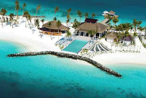 Luftfoto af en tropisk resort ved havet med en pool, hvide strande og palmer. (AI-genereret tekst)