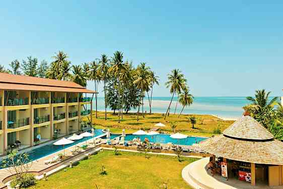 Et feriested med en pool, liggestole og parasoller, tæt på stranden med palmer. (AI-genereret tekst)