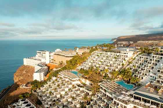 Hotelkompleks på en klippe med swimmingpools og havudsigt. (AI-genereret tekst)