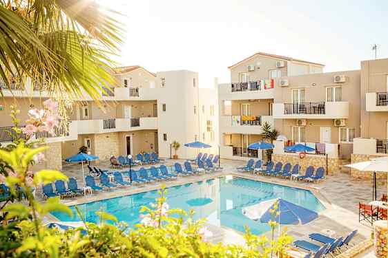 Billede af en pool med liggestole og parasoller omgivet af bygninger. (AI-genereret tekst)