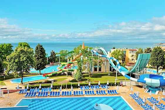 En vandland ved havet med vandrutsjebaner og pools omgivet af liggestole og parasoller. (AI-genereret tekst)