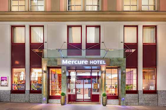 Indgangen til Mercure Hotel med skilt og facade. (AI-genereret tekst)