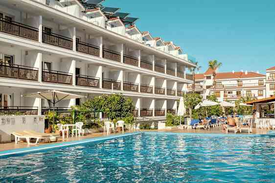 Hotelbygning ved en swimmingpool. (AI-genereret tekst)