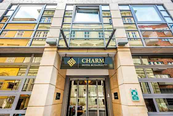 Indgangen til et hotel med skiltet "Charm Hotel Budapest". (AI-genereret tekst)