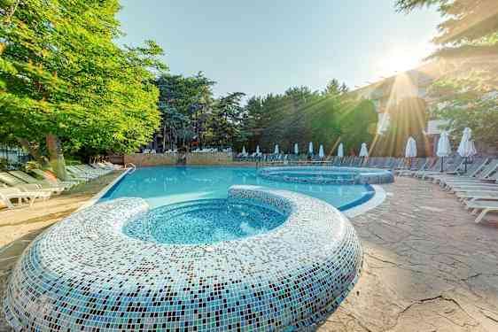 Udendørs pool med liggestole og træer i baggrunden. (AI-genereret tekst)