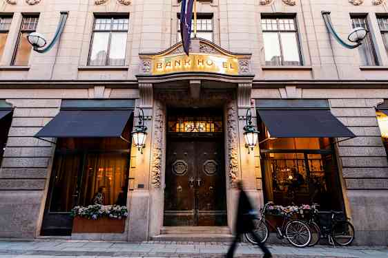 Bygningsfacade med indgangen til Bank Hotel, tydelige detaljer og belysning. (AI-genereret tekst)