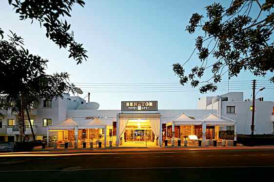 Indgangen til Senator Hotel Apartments med aftensbelysning. (AI-genereret tekst)