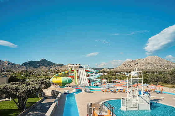 En vandpark med forskellige vandrutsjebaner og pools, omgivet af bjerge. (AI-genereret tekst)