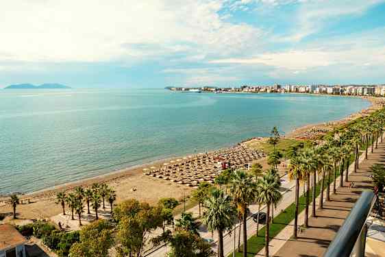 Strand med parasoller og havet i baggrunden. (AI-genereret tekst)