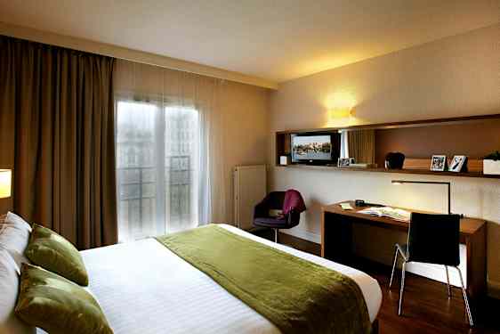 Hotelværelse med dobbeltseng og skrivebord. (AI-genereret tekst)