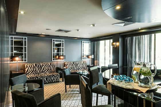 Et rum med møbler med zebramønster og glasborde. (AI-genereret tekst)