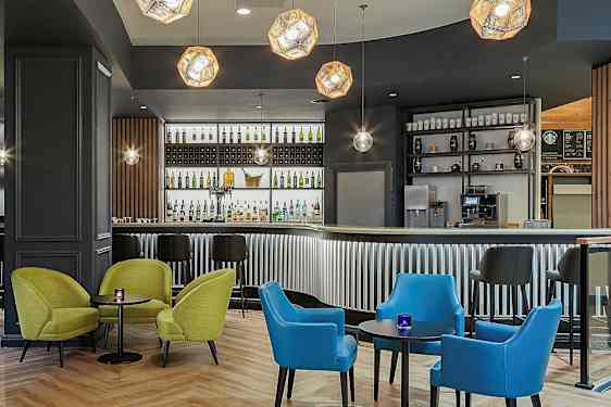 En moderne bar med farverige siddepladser og belysning. (AI-genereret tekst)