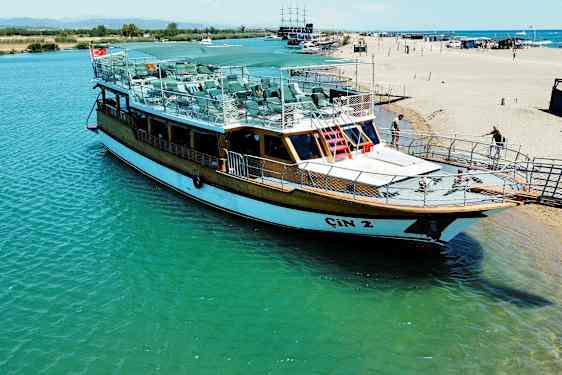 En båd ligger ved en kaj nær stranden. (AI-genereret tekst)