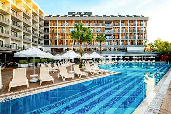Et hotel ved en pool med liggestole og parasoller. (AI-genereret tekst)