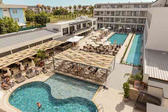 Hotellets poolområde med liggestole, parasoller og servering ved poolen. (AI-genereret tekst)