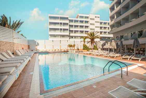 Hotelpool med solsenge og parasoller på omkringliggende terrasse. (AI-genereret tekst)