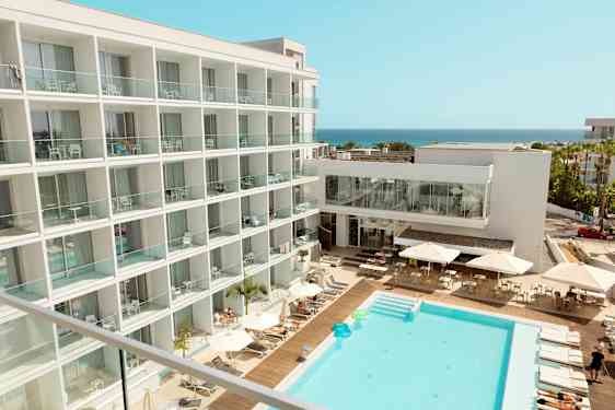 Hotel med poolområde og udsigt mod havet. (AI-genereret tekst)