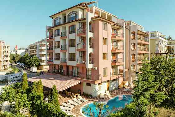 Bygning med rosa facade, altaner og en pool foran. (AI-genereret tekst)