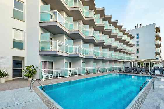 Hotelfacade med altaner og pool i forgrunden. (AI-genereret tekst)