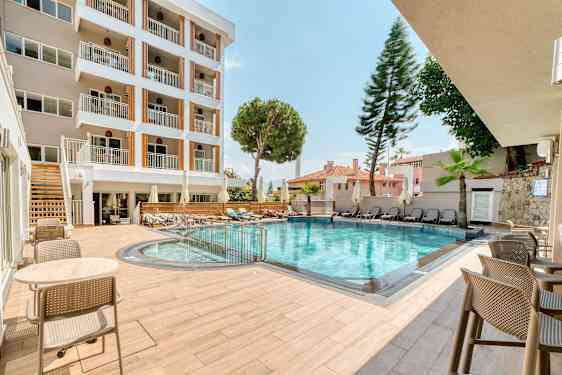 Hotellets udendørs pool med siddepladser og liggestole. (AI-genereret tekst)