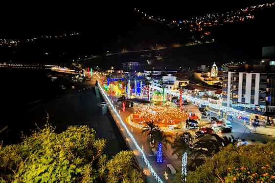 By ved havet om natten med belysning og dekorationer. (AI-genereret tekst)