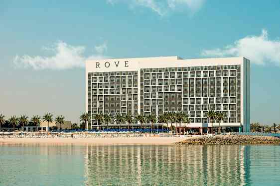 Et hotel ved en strand med palmer. (AI-genereret tekst)