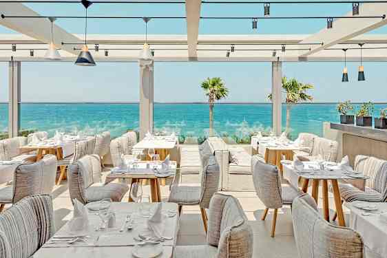 En restaurant med siddepladser ved havet. (AI-genereret tekst)