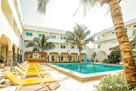 Udendørsområde med pool, liggestole og omkringliggende bygninger. (AI-genereret tekst)