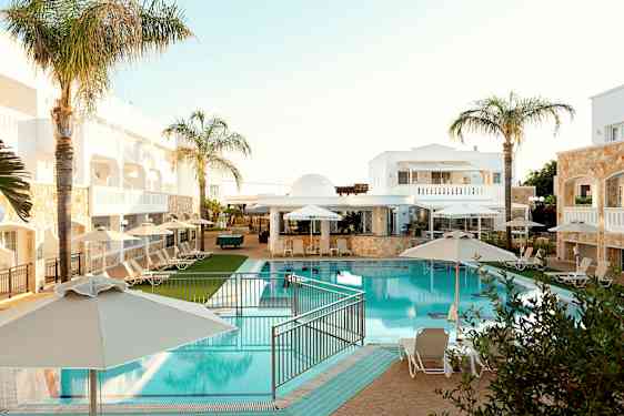 Hotelområde med pool, liggestole og parasoller. (AI-genereret tekst)