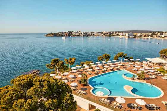 Billede af et poolområde med udsigt over kysten og havet. (AI-genereret tekst)