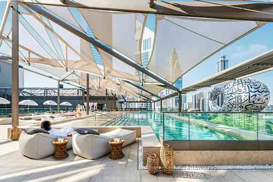 En moderne udendørs pool med siddepladser og udsigt over byens skyline. (AI-genereret tekst)