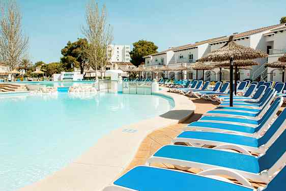 Billede af en pool med solsenge og parasoller ved et hotel. (AI-genereret tekst)