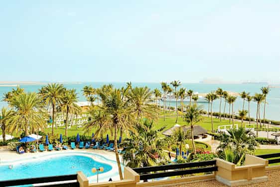 Billede af en strandresort med pool, palmer og havudsigt. (AI-genereret tekst)