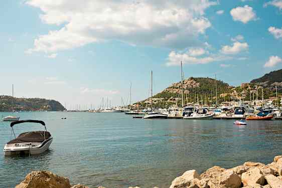 Billede af en havn med både og bjerge i baggrunden. (AI-genereret tekst)