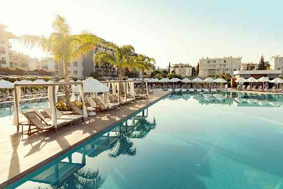 En pool med liggestole og parasoller i en resorts miljø. (AI-genereret tekst)