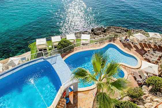 Poolområde med udsigt til havet. (AI-genereret tekst)