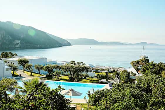 Et ferieanlæg ved havet med pool og grønne områder. (AI-genereret tekst)