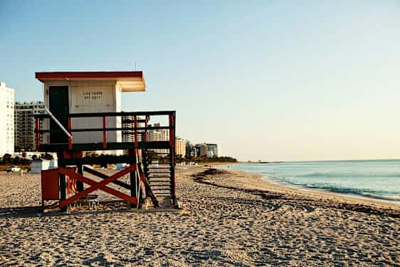 Livreddertårn på en sandstrand ved havet. (AI-genereret tekst)