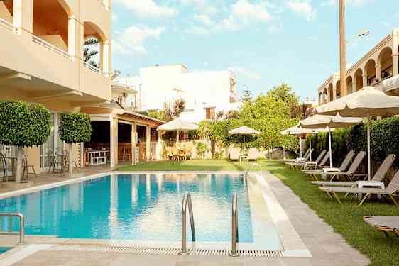 Hotelområde med pool, liggestole og parasoller. (AI-genereret tekst)