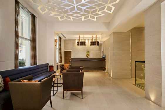 Et moderne indrettet lobbyområde med siddepladser og receptionsdisk. (AI-genereret tekst)