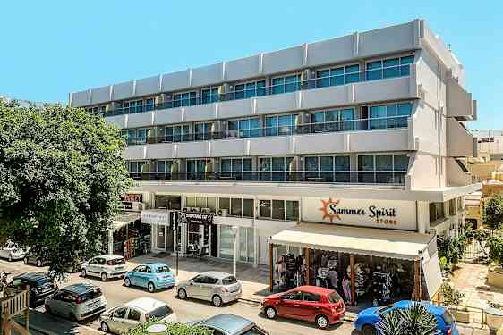 En fleretagers bygning med butik og biler parkeret foran. (AI-genereret tekst)