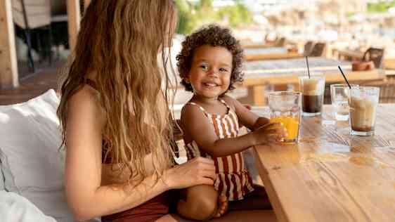 Mor og datter drikker kaffe og juice på deres sommerferie