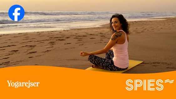 Kvinde sidder på yogamåtte på stranden