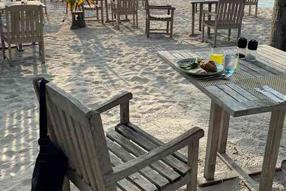 Bord og stole på strand i morgensol