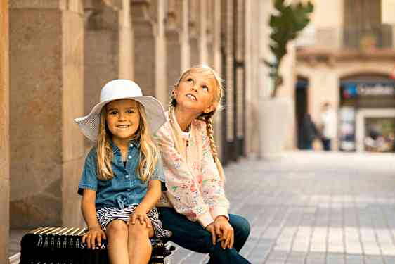 To piger sidder på en kuffert