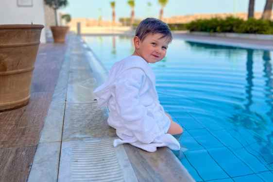 Barn sidder ved poolen