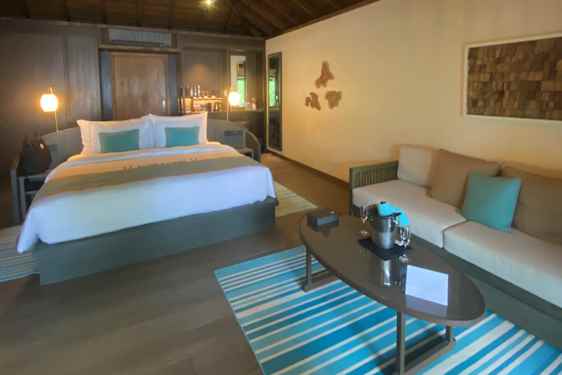 Indenfor i en villa med stor seng og loungeområde